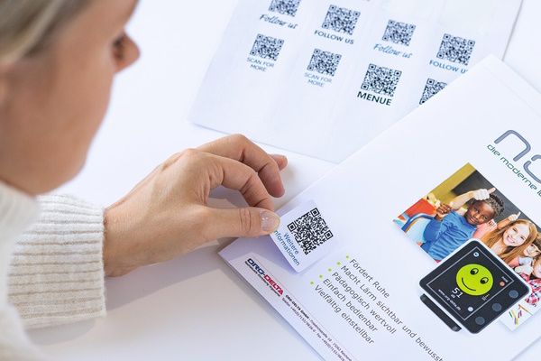 Applicazione di etichette con codice QR su brochure informative
