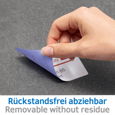 Eine Hand zieht einen abziehbaren Aufkleber ab, auf dem "Rückstandsfrei abziehbar" steht. Der Hintergrund ist grau.