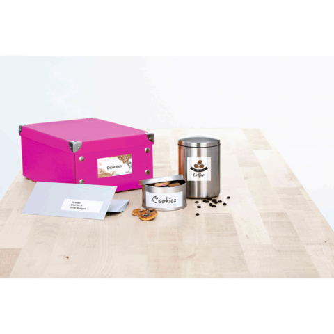 Bunte Kiste mit Aufkleber "Dekoration", Metallbehälter mit "Kaffee" und Dose mit "Cookies" auf einem Holztisch.