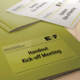 Handouts für ein Kick-off-Meeting in einer grünen Mappe, mit dem Titel "Handout Kick-off Meeting" deutlich sichtbar.