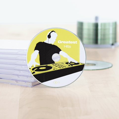 CD intitolata 'Greatest Hits', posizionata su un tavolo, circondata da custodie di CD vuote.