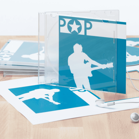 CD-Hülle mit blauem Cover und Silhouette eines Musikers, umgeben von ähnlichen Drucksachen und Kopfhörern.