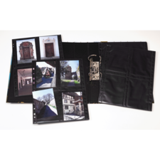 Ein Fotoalbum mit mehreren Seiten, die Bilder von historischen Gebäuden und Straßen zeigen, liegt geöffnet auf einem Tisch.