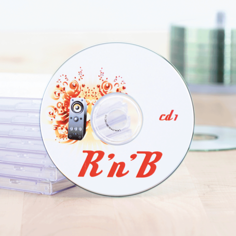 R'n'B CD mit einem Lautsprecher-Design, auf einem Tisch neben transparenten CD-Hüllen.