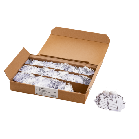 Ein offener Karton mit mehreren weißen Etiketten, die ordentlich angeordnet sind, und einem Haufen lose Etiketten daneben.