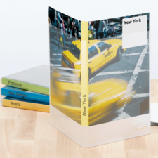 Gelbes Taxi auf einer Straßenkreuzung in New York, umgeben von einem transparenten Ordner mit dem Aufdruck "New York".
