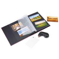 Ein Fotoalbum mit mehreren Bildern, einer transparenten Schutzfolie und einem Kleber, daneben eine Postkarte.